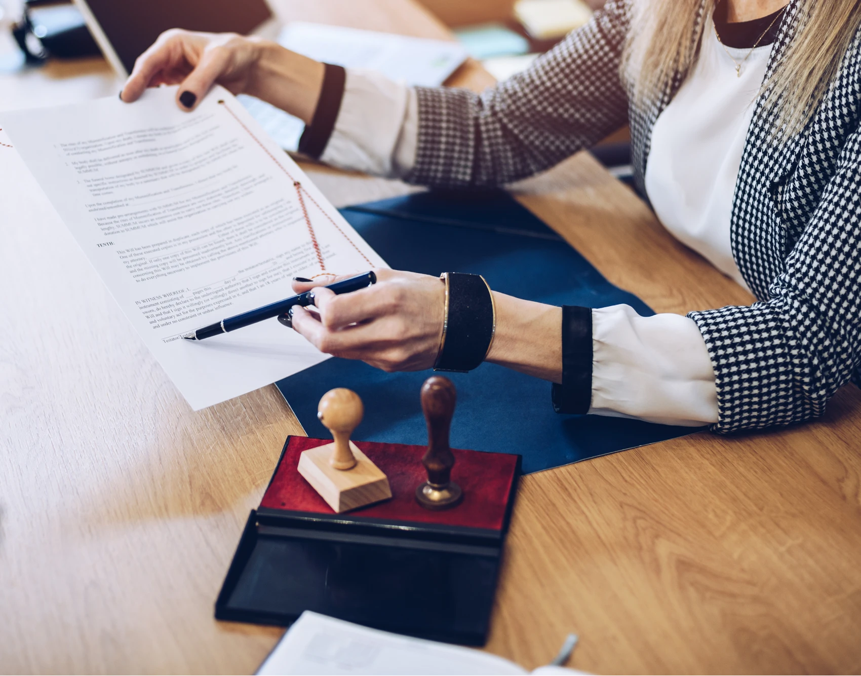 Businesswoman reviewing documents with stamps nearby